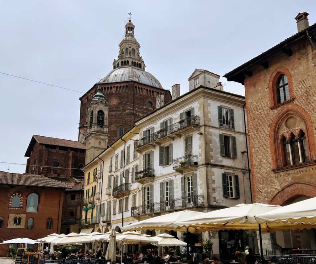 Pavia Piazza Della Vittoria With Cafes White Umbrellas And Cathedral Dome
