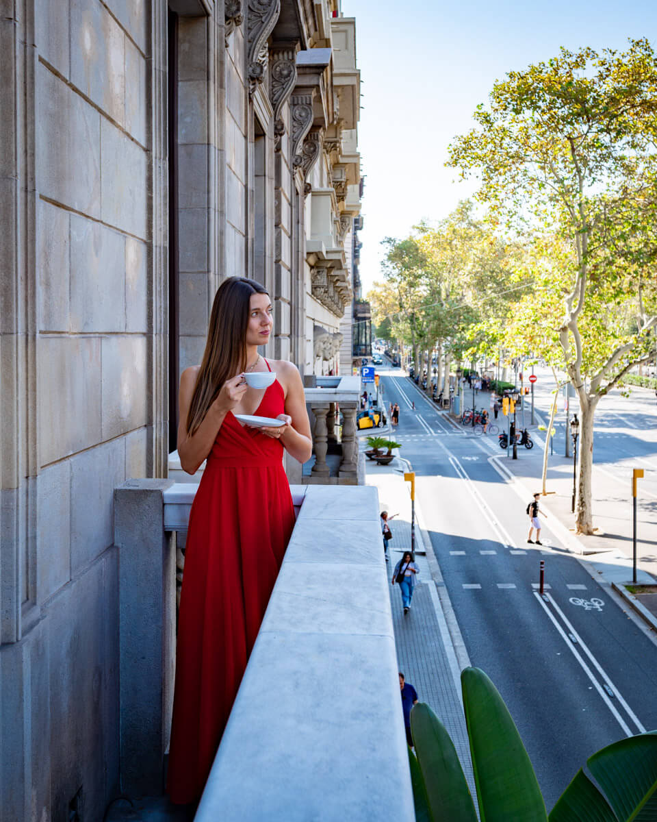 standing on a balcony over the streets of Barcelona with a cup of coffee