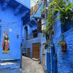 Old City Jodhpur Rajasthan India Streets With Painted Blue Buildings And Mural Of Indian Woman In Pink And Green Sari